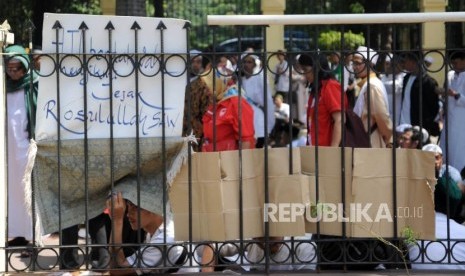 Massa   HTI saat menunggu hasil sidang pembacaan putusan gugatan Hizbut Tahrir Indonesia (HTI) di Pengadilan Tata Usaha Negara (PTUN), Jakarta, Senin (7/5).