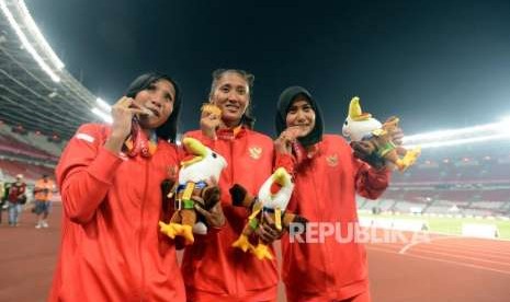 Atlet lari Indonesia Putri Aulia (tengah) bersama Ni Made Arianti Putri (kiri) dan Endang Sari Sitorus memperlihatkan medali usai pertandingan babak final nomor 100 meter putri T13 Asian Para Games 2018 di Stadion Utama Gelora Bung Karno, Jakarta, Rabu (10/10).