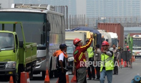 Petugas mengatur lalu lintas saat terjadi kemacetan di ruas jalan Tol Jakarta-Cikampek di Wilayah Kota Bekasi, Jawa Barat, Kamis (16/11).