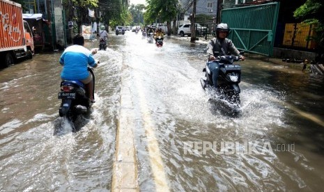 Warga melintas di jalan memasui komplek perumahan Green Garden, Jakarta Barat.