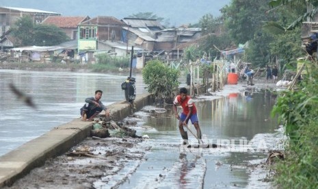 A number of residents cooperate to clean up the remaining flood mud in Bantaran Citarum street, Bojongsoang District, Bandung Regency, December 18, 2017.