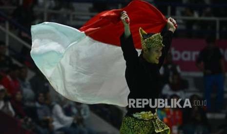 Pesilat Indonesia Sugianto mengibarkan bendera merah putih usai pertandingan cabang olahraga silat Asian Games 2018 kategori tunggal putra di Padepokan Pencak Silat TMII, Jakarta, Rabu (29/8).