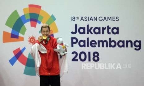 Pesilat Indonesia Hanifan Yudani Kusumah menggigit medali emas usai mengalahkan pilat Vietnam Thai Linh Nguyen pada cabang olahraga silat Asian Games 2018 kategori kelas 55-60 kilogram  di Padepokan Pencak Silat TMII, Jakarta, Rabu (29/8).