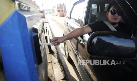 Pengendara menggunakan uang elektronik saat memasuki pintu masuk tol cikarang utama, Bekasi, Jawa Barat, Jumat (30/3).PT Jasa Marga (Persero) Tbk mengakui pemberlakuan elektronifikasi jalan berhasil mencegah risiko penularan Covod-19.  