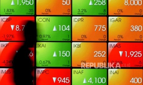 Pekerja melintas di dekat layar pergerakan Indeks Harga Saham Gabungan (IHSG) di Bursa Efek Indonesia (BEI), Jakarta, Rabu (19/9).