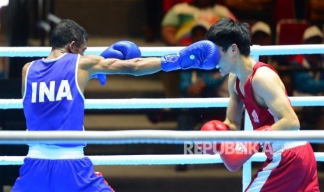 Petinju Putra Indonesia Blasius Kali Mario (biru) saling melancarkan pukulan saat berhadapan dengan petinju China Wei Tu Po saat tarung pada kelas 49 kg, di ajang Invitation Tournament Asian Games 18 di Jakarta, Ahad (11/2).