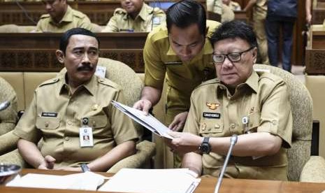 Menteri Dalam Negeri (Mendagri) yang juga Kepala Badan Nasional Pengelola Perbatasan (BNPP) Tjahjo Kumolo (kanan) bersiap mengikuti rapat kerja dengan Komisi II DPR di Komplek Parlemen, Senayan, Jakarta, Senin (17/9).