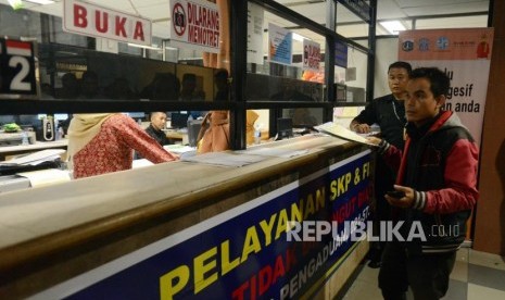 Warga menyelesaikan pembayaran pajak kendaraan bermotor di Kantor Samsat Polda Metro Jaya, Jakarta.