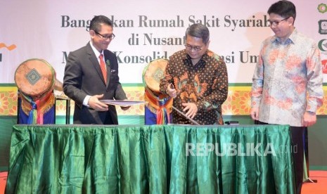 Ketua Umum Majelis Upaya Kesehatan Islam seluruh Indonesia (MUKISI) Masyhudi (kiri) melakukan penandatanganaan bersama Direktur Wholesale Banking Mandiri Syariah Kusman Yandi (tengah) disaksikan Dirut Mandiri Syariah Toni EB Subari saat penandatanganan MoU penggunaan produk layanan syariah di sektor kesehatan disela acara pembukaan 1st Internasional Islamic Healthcare Conferance & Expo (IHEX) di Jakarta Convention Center, Selasa (10/4).