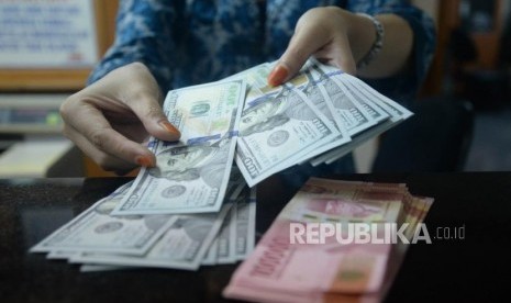 Petugas menghitung pecahan dolar Amerika Serikat di salah satu gerai penukaran mata uang asing di Jakarta. ilustrasi