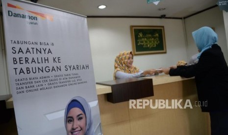 Petugas melayani nasabah di salah satu kantor Bank Danamon Syariah di Jakarta, Selasa (16/10).