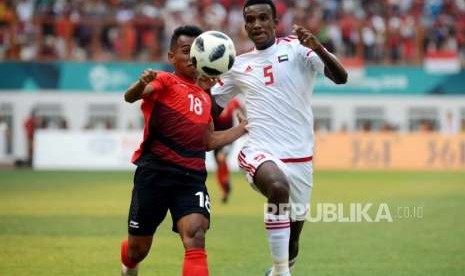 Pesepakbola Indonesia Irfan Jaya (kiri) bersama Pesepakbola Uni Emirat Arab Esmail Alali mengejar bola pada pertandingan babak 16 besar cabang sepak bola Asian Games 2018 di Stadion Wibawa Mukti, Cikarang, Bekasi, Jawa Barat, Jumat (24/8).