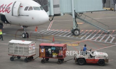 Petugas masukan barang milik penumpang ke bagasi pesawat di Bandara Internasional Soekarno,-Hatta, Tanggerang,Banten, Kamis (7/2).