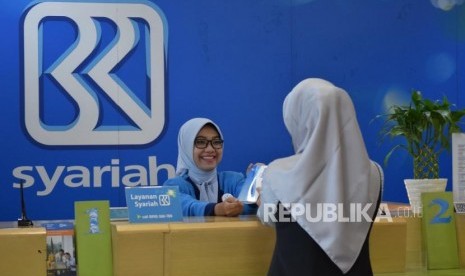 Petugas melayani transaksi nasabah di kantor layanan BRI Syariah, Jakarta, Rabu (24/10).