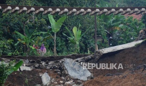 Warga melihat kondisi jalur kereta api jurusan Sukabumi-Bogor yang menggantung akibat pondasi longsor di Kampung Maseng, Cijeruk, Kabupaten Bogor, Jawa Barat, Selasa (6/2).