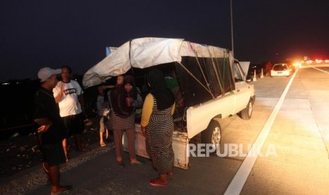 Pemudik menikmati makanannya saat berbuka puasa di Ruas Jalan Tol Fungsional Kertasari, Tegal, Jawa Tengah, Ahad (10/6).