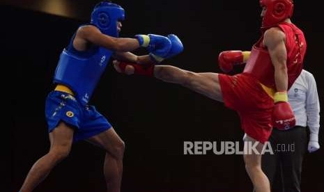 Atlet  Indonesia   Riyaya Puja (biru) bertarung melawan atlet  China Zhanwei Shi  (merah) pada babak  semi final 70 kilogram Sanda PutraWushu Asian Games 2018 di JIExpo Kemayoran, Jakarta,  Rabu (22/8).