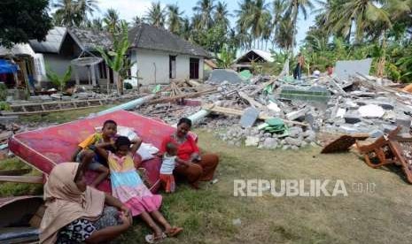 Sejumlah warga beraktivitas di dekat puing-puing bangunan di Sambelia, Lombok Timur, Nusa Tenggara Barat, Selasa (21/8).