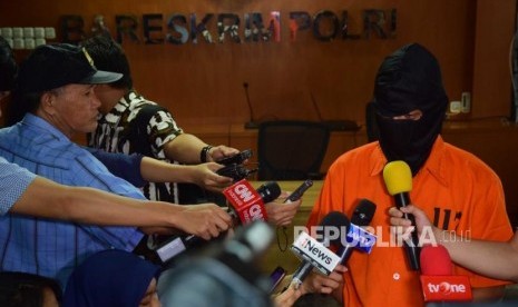 Tersangka deface website Bawaslu memberikan keterangan kepada media  saat dihadirkan dalam konfrensi pers di  Bareskrim Polri, Jakarta, Jumat (6/7).