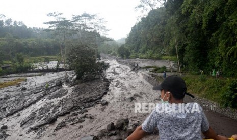 Aliran Lahar Dingin Meluas. Warga menonton lahar dingin dari Gunung Agung yang mulai memenuhi Sungai Yeh Sah di Rendang, Bali, Rabu (29/11).