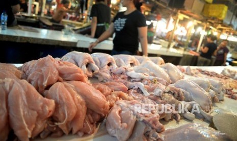  Pedagang melayani pembeli daging ayam potong di Pasar Senen, Jakarta, Ahad (14/1).