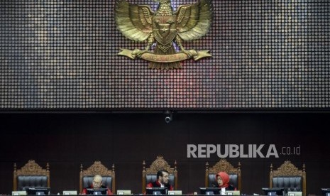 Ketua Majelis Hakim Mahkamah Konstitusi Anwar Usman (tengah) bersama Majelis Hakim Wahiduddin Adams (kiri) dan Enny Nurbaningsih (kanan) berbincang disela jalannya sidang perdana uji materi UU KPK di Gedung Mahkamah Konstitusi, Jakarta, Senin (30/9).