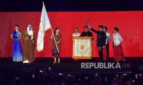 Gubernur DKI Jakarta, Anies Baswedan (kanan) bersiap memberikan obor pertama Penyelanggaraan Asian Games  pada penutupan Asian Games ke 18 di Stadion Utama Gelota Bung Karno, Jakarta, Ahad(2/9).