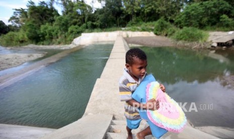 Seorang anak melintas di pengendali sedimen Danau Sentani di Sungai Harapan, Kampung Nolokla, Kabupaten Jayaura, Papua. (Ilustrasi)