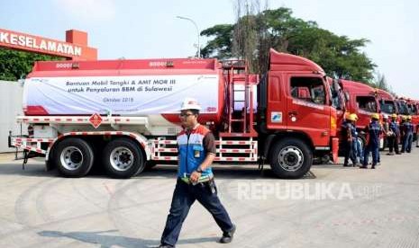 Petugas melintas didekat mobil tangki yang akan mendistribusikan BBM dan Avtur menuju ke Sulawesi, di Terminal Bahan Bakar Minyak (TBBM) Plumpang, Jakarta, Selasa (2/10).