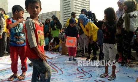 Anak-anak saat bermain permainan tradisional saat Hari Bebas Kendaraan Bermotor (HBKB) di Jalan Jenderal Sudirman, Jakarta, Ahad (18/11).