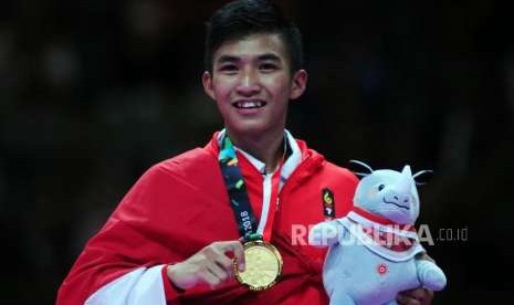 Karateka Indonesia Arrosyiid Rifki Ardiansyah memperlihatkan medali usai memenangkan pertandingan cabang olahraga karate Asian Games 2018 kategori kumite 60 kilogram di JCC Plennary Hall, Jakarta, Ahad (26/8).