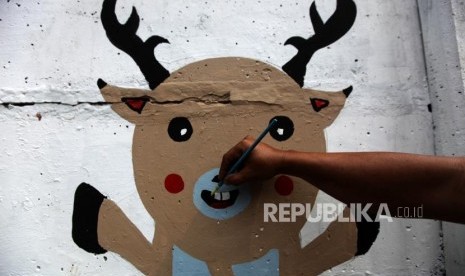 Petugas PPSU membuat mural maskot Asian Games di Kawasan Setiabudi, Jakarta, Rabu (4/7).