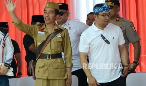 Presiden RI Joko Widodo (Jokowi) menggunakan kostum pejuang didampingi Gubernur Jawa Barat Ridwan Kamil (kedua kanan) melambaikan tangan saat hadir pada acara Bandung Lautan Sepeda dalam rangka Hari Pahlawan, di kawasan Gasibu, Kota Bandung, Sabtu (10/11).