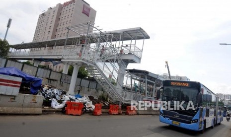 Bus Transjakarta melintas didekat pembangunan Halte Busway Transjakarta BNN di kawasan Cawang, Jakarta, Jumat (9/3).