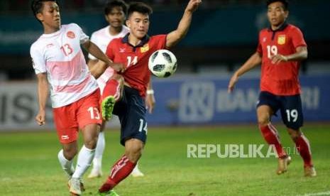 Pesepak bola Indonesia  Febri Hariyadi berusaha melewati pemain Laos pada laga penyisihan Grup A cabang sepak bola Asian Games 2018 di Stadion Patriot, Bekasi, Jumat(17/8).