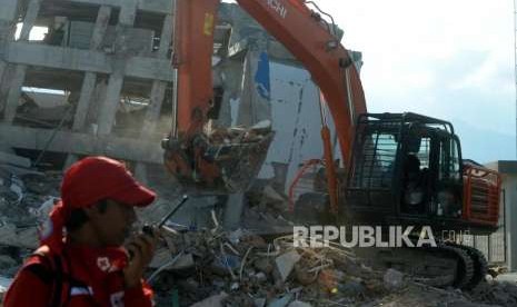 Sejumlah alat berat saat melakukan proses evakuasi korban yang tertimbun reruntuhan bangunan Hotel Roa Roa, Palu, Sulawesi Tengah, Senin (1/10).