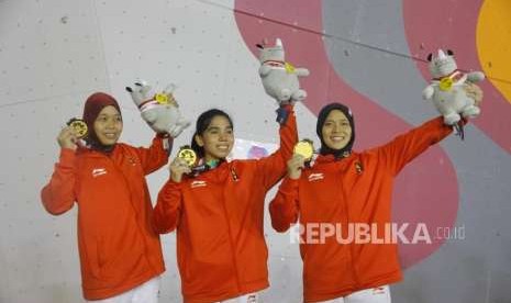 Emas dari Speed Relay Putri. Atlet Panjat Dinding Putri Indonesia Puji Lestari, Rajiah Sallsabillah, dan Aries Susanti Rahayu (dari kiri) mengikuti upacara pengalungan medali pada cabang panjat dinding nomor speed relay putri Asian Games 2018 di Komplek Olahraga Jakabaring, Palembang, Senin (27/8).