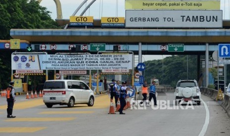 Sejumlah petugas mengatur lalu lintas saat penerapan sistem ganjil-genap di Gerbang Tol Tambun, Bekasi, Jawa Barat, Selasa (4/12).