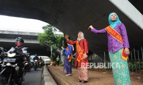 Polisi Wanita dari Polres Jakarta Timur sedang mengatur lalu lintas dengan mengenakan baju  kebaya di kawasan Cawang, Jakarta Timur, Jumat(20/4).