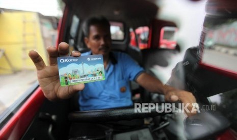 Pengemudi angkutan umum jurusan Lebak Bulus memperlihatkan kartu Ok Otrip di Kawasan Pondok Labu, Jakarta, Senin (19/2).