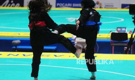 Pesilat Indonesia Pipiet Kamelia (pita biru) bertanding melawan Pesilat Singapura Nurul Suhaila Mohd Saiful pada babak perempat final cabang pencak silat putra kelas D 60-65 kg Asian Games 2018 di Padepokan Pencak Silat TMII, Jakarta, Jumat (24/8).