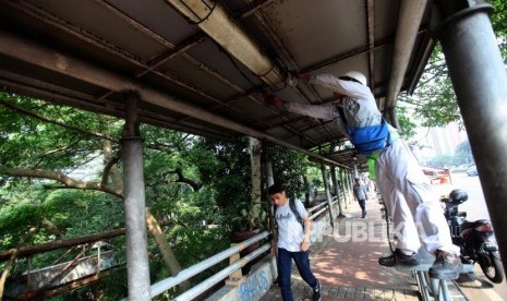 Petugas memperbaiki lampu penerangan jalan umum (PJU). ilustrasi