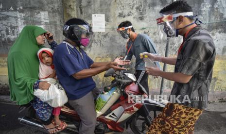 Pengendara sepeda motor diberikan cairan pembunuh kuman atau hand sanitizer (ilustrasi). Kondisi lingkungan hidup berpengaruh terhadap praktik pencegahan dan pengendalian Covid-19. 