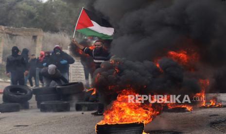  Warga Palestina bentrok dengan tentara Israel di desa Burqa dekat kota Nablus, Tepi Barat, 23 Desember 2021. Bentrokan meletus setelah pemukim Israel tiba untuk memprotes di dekat desa tempat seorang pemukim dibunuh pekan lalu oleh warga Palestina.