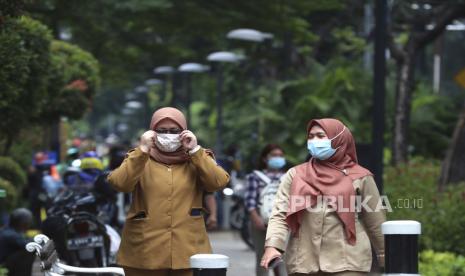  Perempuan pekerja mengenakan masker sebagai pencegahan terhadap wabah virus corona berjalan di atas pejalan kaki di Jakarta, Indonesia Senin, 5 Oktober 2020.