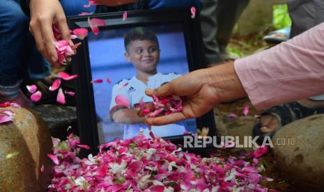 Orang tua Afif Maulana, pelajar SMP yang tewas diduga dianiaya oknum polisi, menabur bunga di pusara anaknya di pemakaman umum (TPU) Tanah Sirah, Padang, Sumatra Barat, Rabu (10/7/2024).