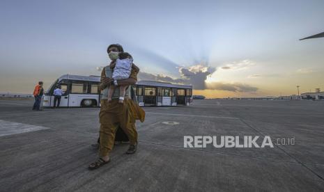  Dalam gambar yang disediakan oleh Angkatan Laut AS, para pengungsi dari Afghanistan menaiki penerbangan menuju Amerika Serikat dari Naval Air Station Sigonella, Italia, Sabtu, 28 Agustus 2021. Pesawat tujuan AS terbang Minggu ke Philadelphia dan Washington, DC membawa AS warga dan warga Afghanistan dievakuasi dari kekacauan di Afghanistan. 