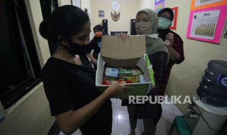 Warga memperlihatkan isi bantuan sembako pemerintah sebagai bantuan pangan akibat wabah COVID-19 di kawasan RW 03 Kebon Kacang, Jakarta, Ahad (12/4/2020). Bantuan sembako Pemprov DKI Jakarta tersebut guna meringankan beban perekonomian warga setempat yang terdampak COVID-19 di wilayah DKI Jakarta selama masa Pembatasan Sosial Berskala Besar (PSBB)