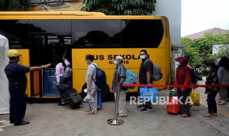 Sejumlah pasien COVID-19 menaiki bus Sekolah yang akan membawa mereka menuju Rumah Sakit Darurat Wisma Atlet di Puskesmas Kecamatan Duren Sawit, Jakarta, Senin (30/11). Tempat tidur di ruang perawatan pasien Covid-19 gejala ringan hingga sedang Rumah Sakit Darurat (RSD) Wisma Atlet Kemayoran, Jakarta Pusat, terisi 57,4 persen dari total kapasitas pada Senin (7/12). 