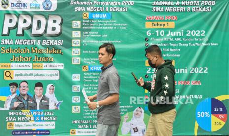 Calon peserta melintas disamping banner sosialisasi Penerimaan Peserta Didik Baru (PPDB)  tahap satu secara daring di SMA 8, Bekasi, Jawa Barat, Senin (6/6/2022). Pemerintah Provinsi Jawa Barat mulai membuka pendaftaran PPDB SMA/SMK tahap satu dari tanggal 6-10 Juni 2022 yang dilaksanakan secara digital guna memudahkan calon anak didik baru dalam memilih pendidikan. 